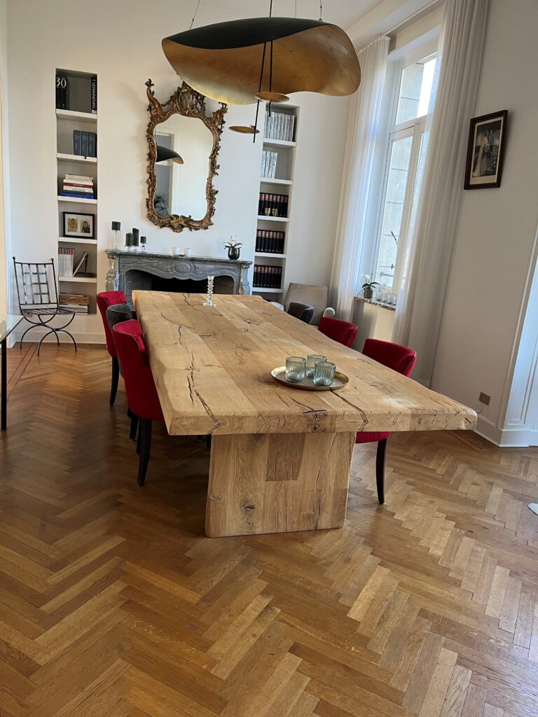 Massieve eiken boom-tafel met natuurlijke randen in een modern interieur in Antwerpen.