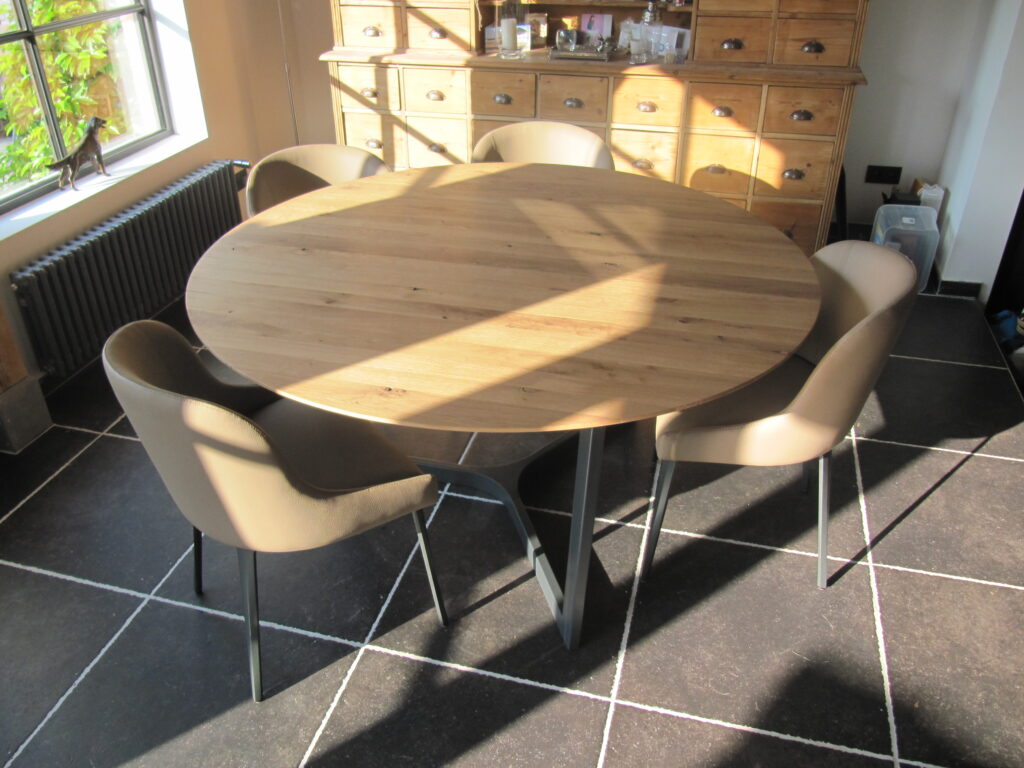 Gezellig dineren aan een grote ronde tafel van notelaar, handgemaakt in Mortsel.